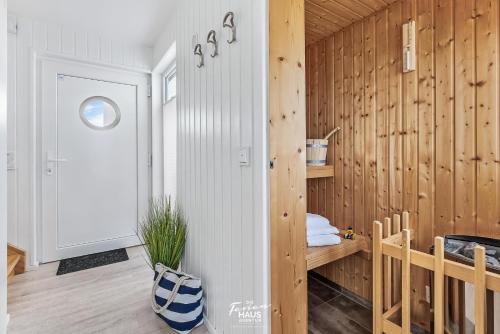 a room with wooden walls and a door with a wooden floor at Bora in Olpenitz