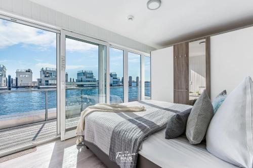 a bedroom with a bed with a view of the water at Bora in Olpenitz