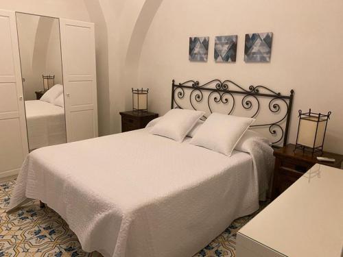 1 dormitorio con cama blanca y espejo en Le Esperidi House, en Ravello