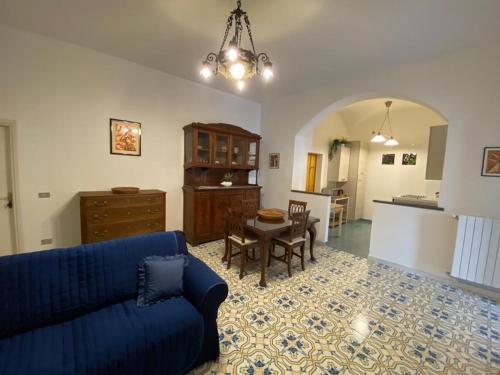 Le Esperidi House في رافيلو: غرفة معيشة مع أريكة زرقاء وطاولة
