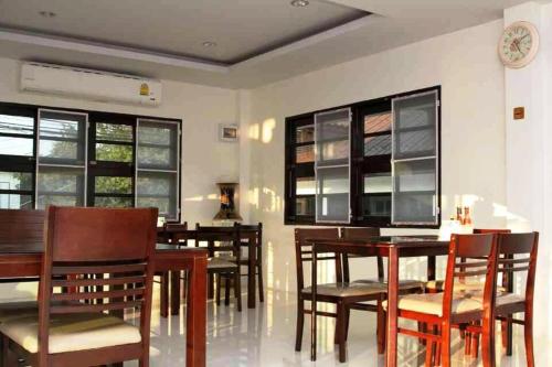 a dining room with tables and chairs and a clock at Chiangrai Green Park Resort in Chiang Rai