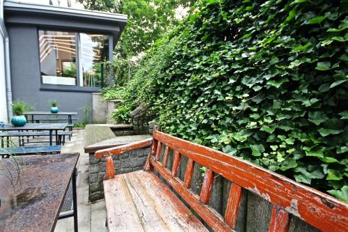 einer Holzbank, die vor einer grünen Hecke sitzt in der Unterkunft Hotel Maximilians in Essen