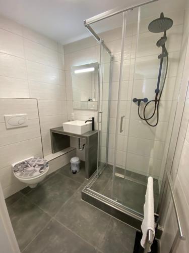 e bagno con doccia, servizi igienici e lavandino. di Gästehaus Glücksmoment a Erfurt