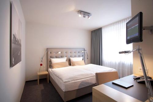 Un pat sau paturi într-o cameră la Hotel Maximilians