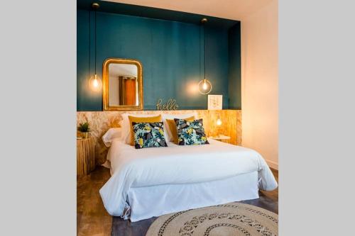 um quarto com uma grande cama branca e um espelho em L'Appart em Ruelle-sur-Touvre