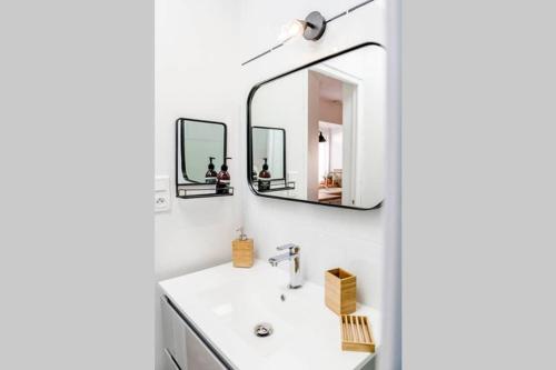 a bathroom with a sink and two mirrors at L'Appart in Ruelle-sur-Touvre