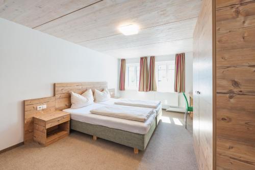 a bedroom with a bed and a wooden wall at Motel Engel - self checkin in Feldkirch