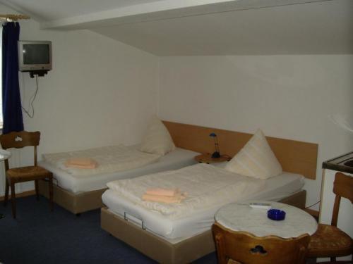 ドルトムントにあるGT Hotelのベッド2台、テーブル、テレビが備わる客室です。