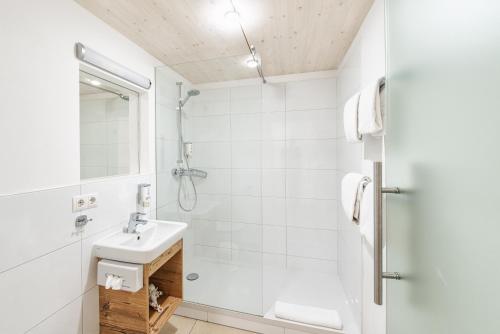 a white bathroom with a sink and a shower at Motel Engel - self checkin in Feldkirch