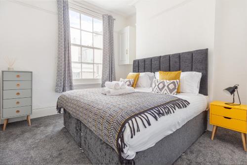 Un dormitorio con una cama grande y una ventana en Guest Homes - Montpellier Villa Apartment, en Cheltenham