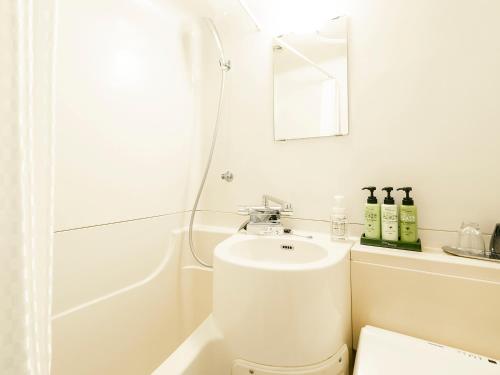 a bathroom with a toilet and a sink and a shower at Hotel Areaone Tokai in Funaishikawa