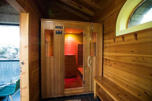 une cabane en bois avec une porte menant à une chambre dans l'établissement Aldeia da Fonte Hotel, à Lajes do Pico