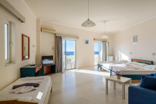 a large living room with two beds and a tv at Regina Hotel in Kissamos