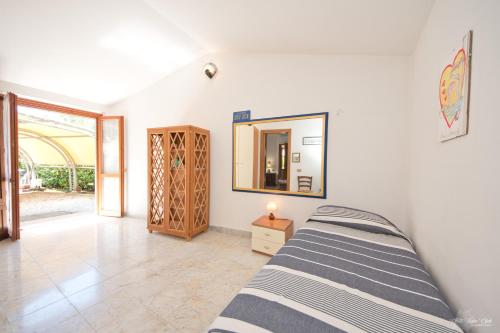 a bedroom with a bed and a mirror on the wall at La casina del Mare in Marina di Massa