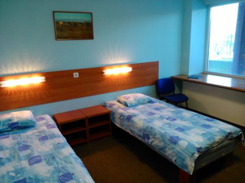 ヴィリャンディにあるMännimäe Guesthouseのベッドルーム1室(ベッド2台、デスク、窓付)