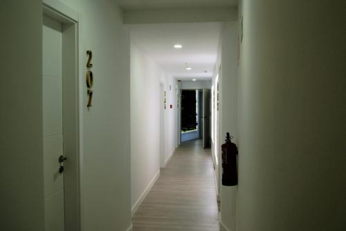 a hallway with white walls and a long hallway with white floors at Hotel La Encomienda in Moraleja