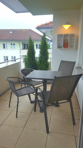 a table and chairs on a balcony with a view of a building at Fewo Wellenreiter Usedom 200 m zum Strand mit Balkon Parkplatz Wlan in Ostseebad Karlshagen