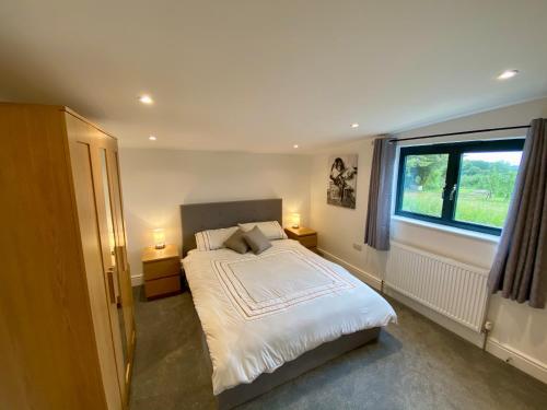 um quarto com uma cama grande e uma janela em Blackberry Cottage em Sutton Valence