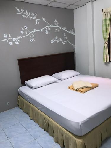a bedroom with a bed with white flowers on the wall at Phang Nga Guesthouse in Phangnga