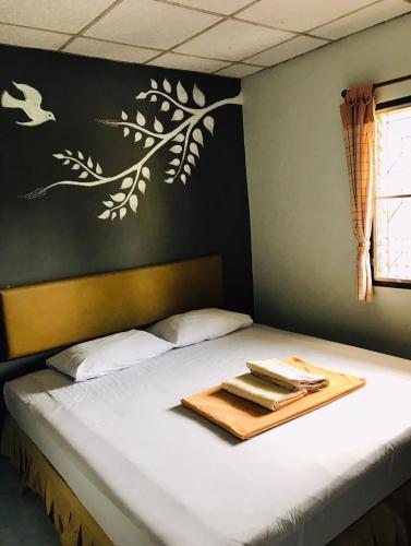 a bed with a tray of towels on it at Phang Nga Guesthouse in Phangnga