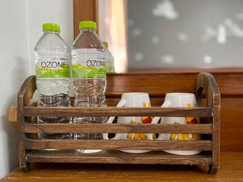 dos botellas de agua en una cesta de madera en Phang Nga Guesthouse en Phangnga