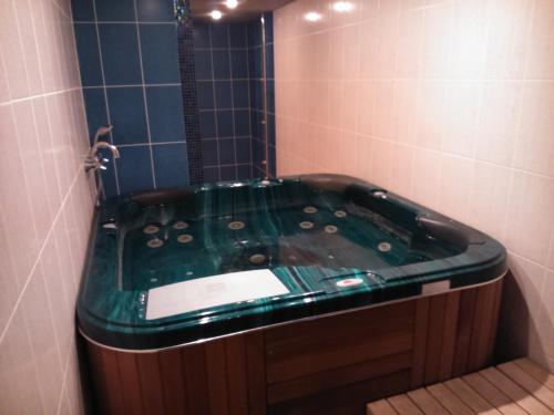 een groen bad in een badkamer met een douche bij Männimäe Guesthouse in Viljandi