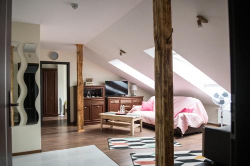 een slaapkamer op zolder met een bed en een televisie bij Apartamenty Królewskie in Chęciny