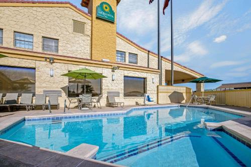 a pool at a hotel with chairs and umbrellas at La Quinta Inn by Wyndham El Paso Cielo Vista in El Paso