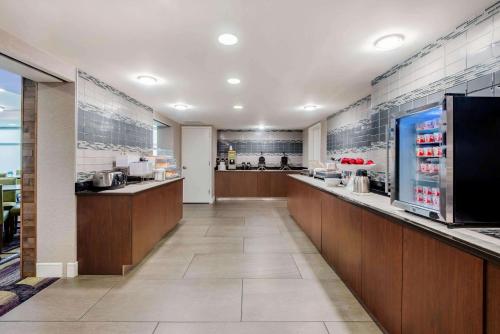 a restaurant with a kitchen with a counter and a counter at La Quinta by Wyndham Baltimore BWI Airport in Linthicum Heights