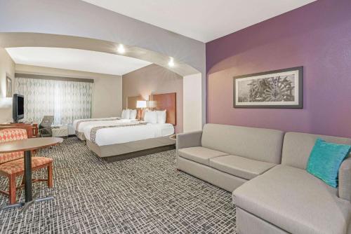 a hotel room with a bed and a couch at La Quinta by Wyndham Oklahoma City -Yukon in Yukon
