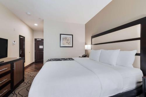 a hotel room with a large bed and a flat screen tv at La Quinta by Wyndham Auburn in Auburn