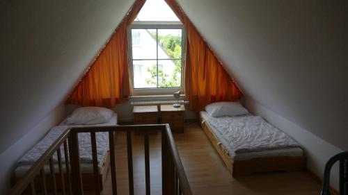 une chambre mansardée avec deux lits et une fenêtre dans l'établissement Wellenberg, à Breege
