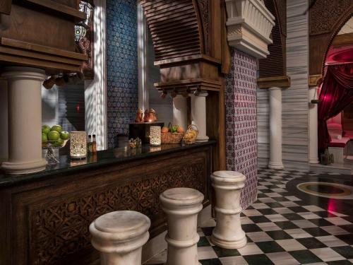 a bar with a checkered floor and two stools at Rixos Premium Belek - The Land of Legends Access in Belek