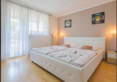 białe łóżko w pokoju z dużym oknem w obiekcie Apartman Andja sea and garden view w mieście Peroj