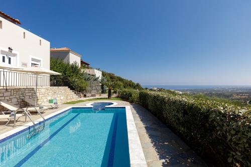 a swimming pool with a view of the ocean at Agios Antonios Villas in Agia Triada