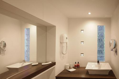 a bathroom with two sinks and two mirrors at Orchard Road Studio Apartment in Hook Norton