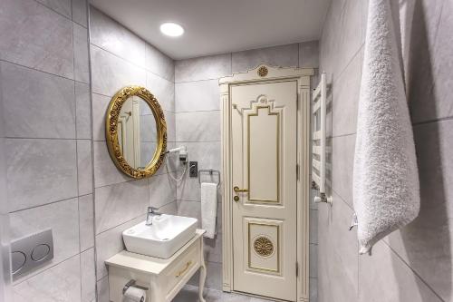 a white bathroom with a sink and a mirror at Hotel Saba in Istanbul
