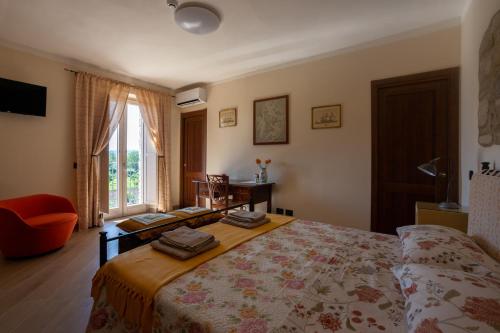 a bedroom with a bed and a chair and a window at Il poggio degli antichi sapori in Paternopoli