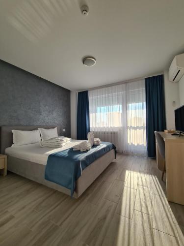a bedroom with a bed and a large window at Turquoise Boutique in Mamaia Nord