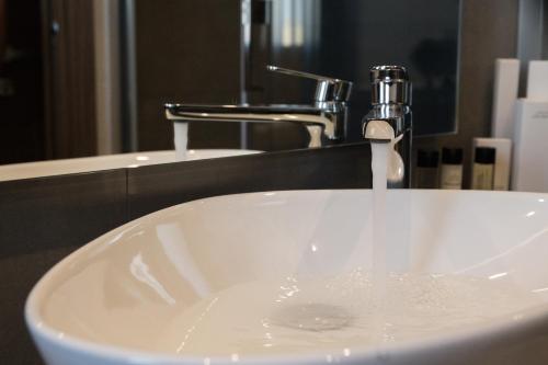 a white sink with a faucet in a bathroom at Giafra Luxury Rooms in Agrigento