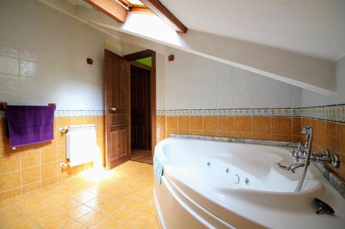 ein Bad mit einer großen Badewanne in einem Zimmer in der Unterkunft Casa de Aldea Peña Sobia in La Plaza