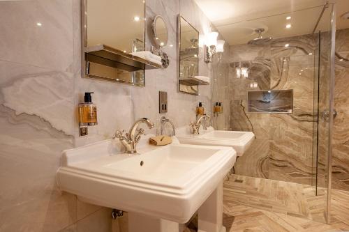 a bathroom with two sinks and a shower at The Fox and Hounds Country Inn in Pickering