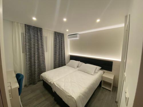 een slaapkamer met een wit bed in een kamer bij DM Sobe in Tuzla