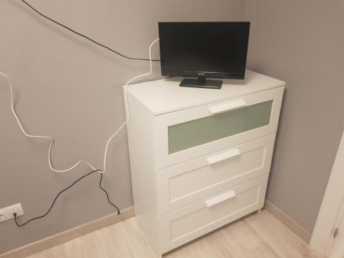 a television on top of a white dresser at Habitaciones en Ronda in Castro-Urdiales