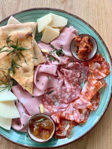 een bord met eten, zoals ham, kaas en andere lekkernijen bij OKRA RESORT & SPA in Drawsko Pomorskie