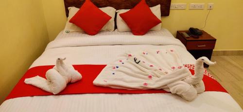 a bed with towels and stuffed animals on it at Hotel Green Plaza in Trichūr