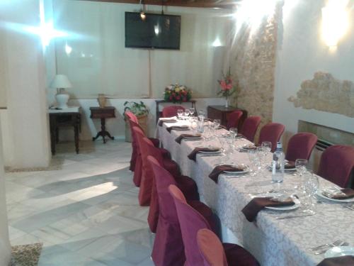 a dining room table filled with chairs and tables at Hospedería del Monasterio in Osuna