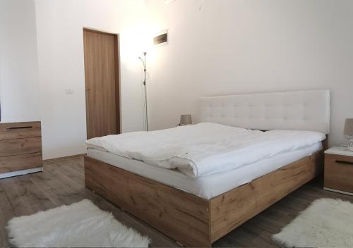 1 dormitorio con 1 cama grande con marco de madera en Neferprod Apartments - IS - CAM 07, en Timisoara