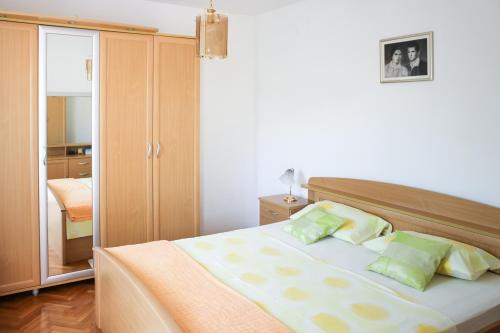 1 dormitorio con 1 cama grande con almohadas verdes en Apartments Marušić, en Vinišće