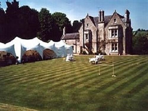 ein großes Haus mit Zelten vor einem Hof in der Unterkunft Burcombe Manor in Barford Saint Martin